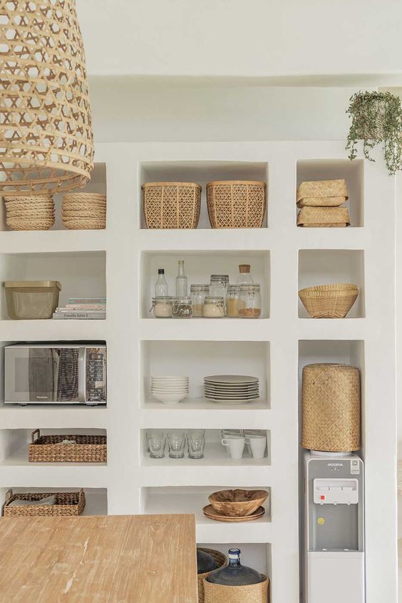 A whole niche wall as an alternative to the pantry with appliances, baskets, china and cups is a very creative idea
