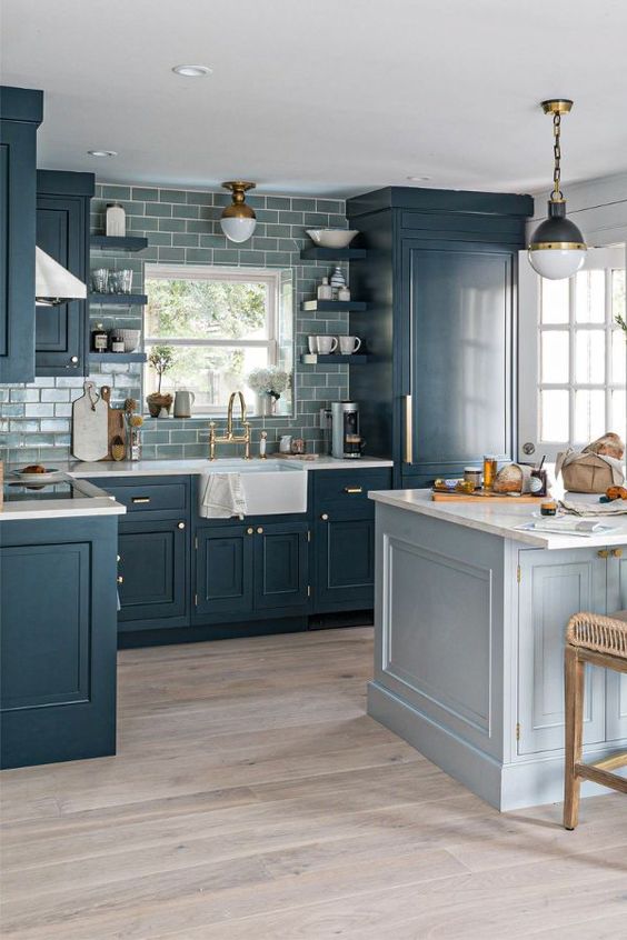 a modern farmhouse kitchen with navy shaker cabinets, a gray subway tile backsplash, a light blue kitchen island, and a lamp on a chain