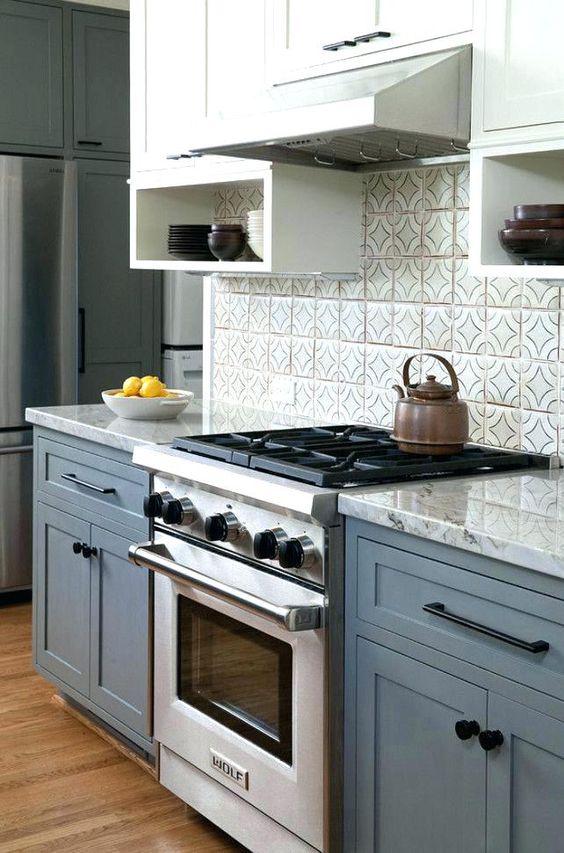 A chic blue and white kitchen with a gray worktop and a gray splashback looks neat, stylish and timeless