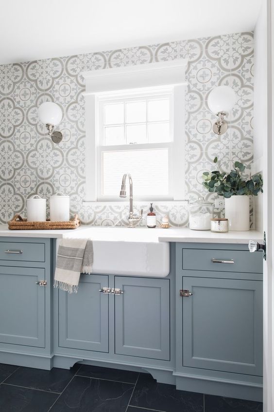 A light blue kitchen with a gray mosaic tile backsplash and metal handles is a beautiful idea with a traditional feel