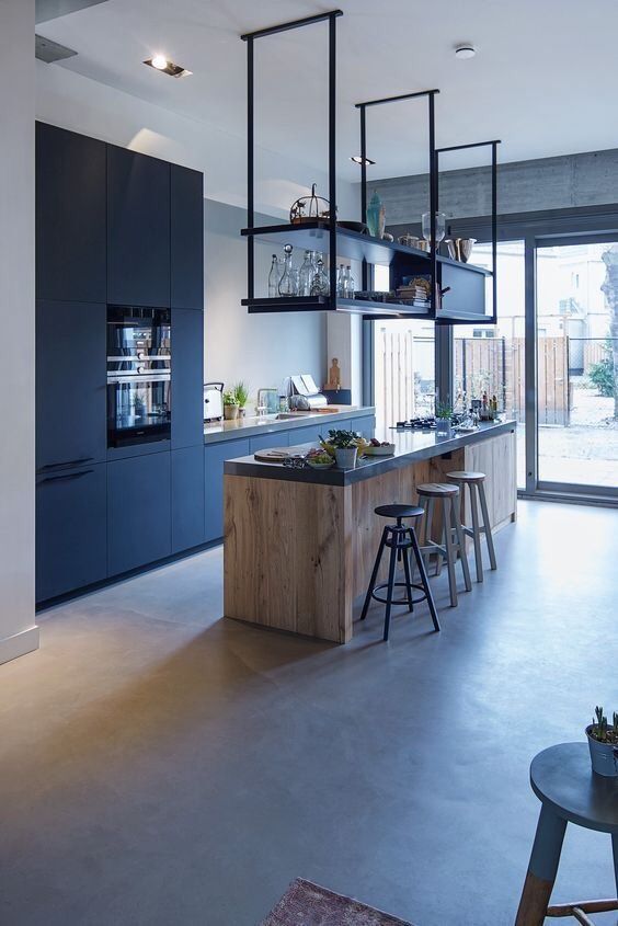 a modern black kitchen with sleek cabinets, a stained kitchen island and hanging black shelf, and black stools