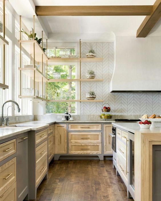 a brightly stained farmhouse kitchen with shaker cabinets, a large range hood, hanging shelves and a kitchen island
