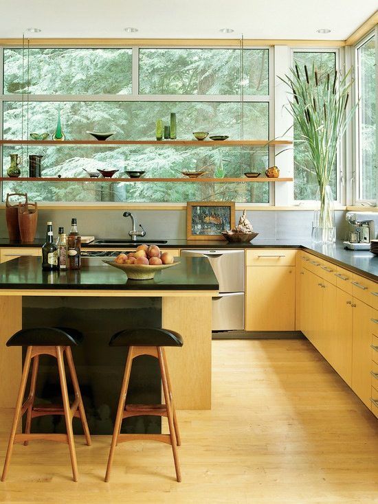 a brightly stained modern kitchen with hanging shelves instead of upper cabinets and a large, contrasting kitchen island
