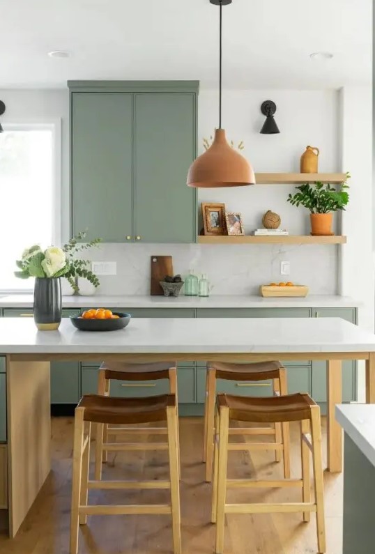 a sage green kitchen with open shelving and only base cabinets, a kitchen island that doubles as a dining table