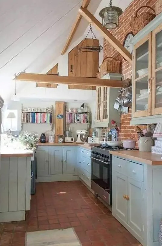 A cottage kitchen with exposed beams, light blue shaker cabinets, butcher block countertops, and tile flooring is cozy and cool