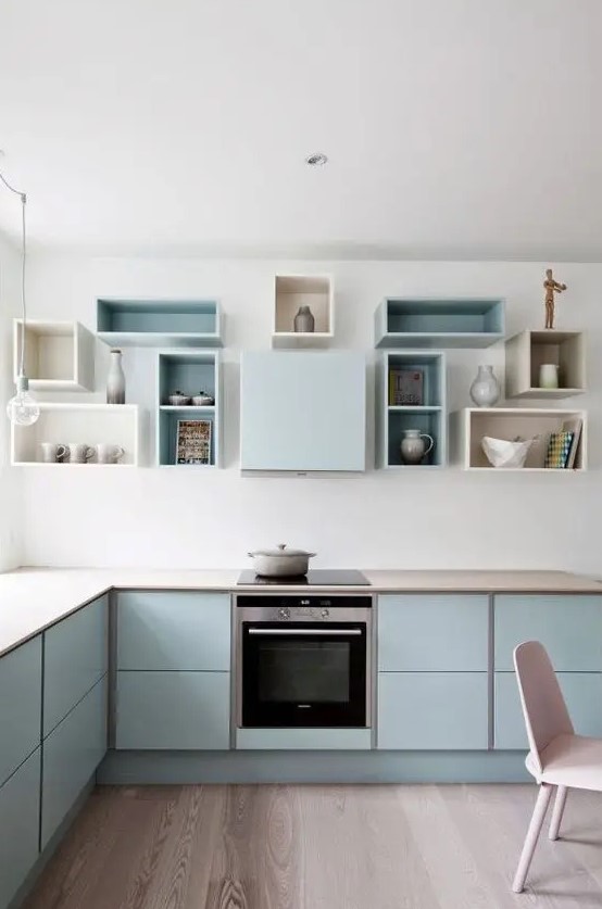 a pastel blue Scandinavian kitchen with elegant cabinets, box shelves on the wall and built-in appliances