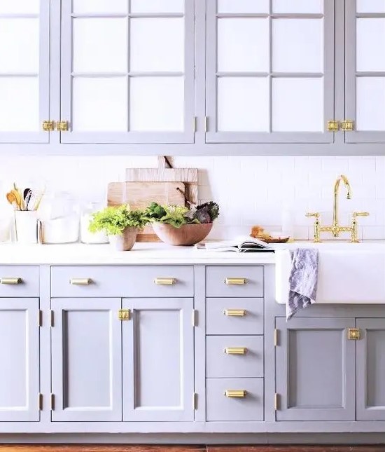 A romantic purple kitchen with a white subway tile backsplash and white countertop and gold accents