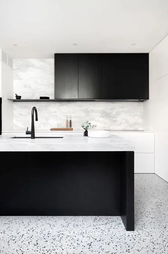 a stylish black and white kitchen with sleek white and black cabinets, a large kitchen island, black fixtures and lots of greenery