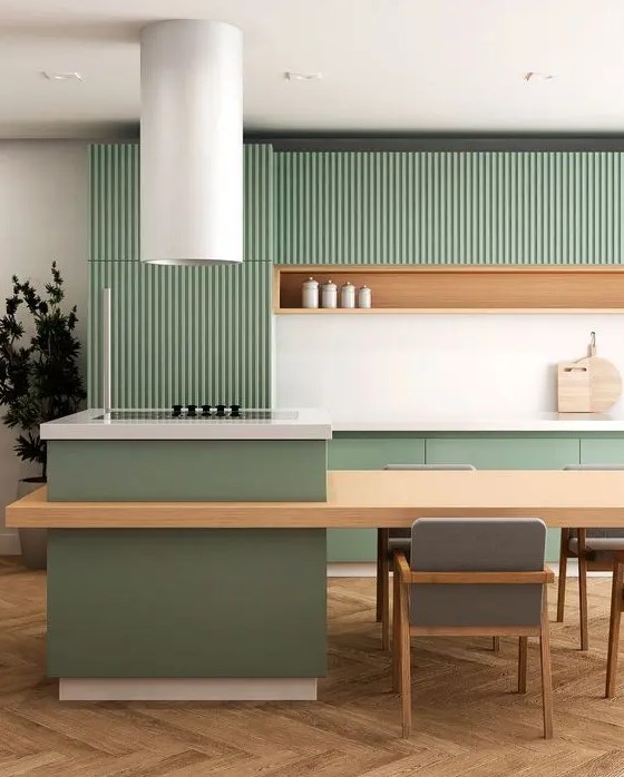 a minimalist kitchen with ribbed and simple green cabinets, a niche shelf, a large kitchen island and a round extractor hood