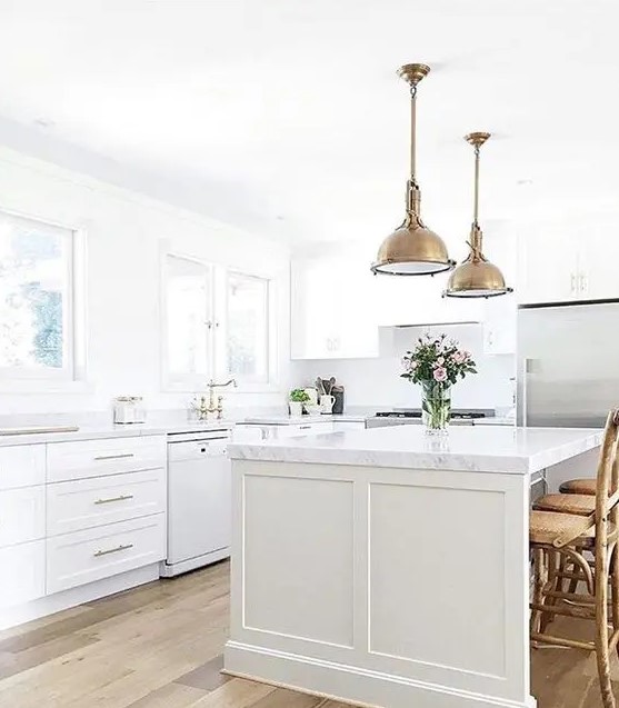 A farmhouse kitchen with vintage brass accents and marble countertops for an eye-catching touch