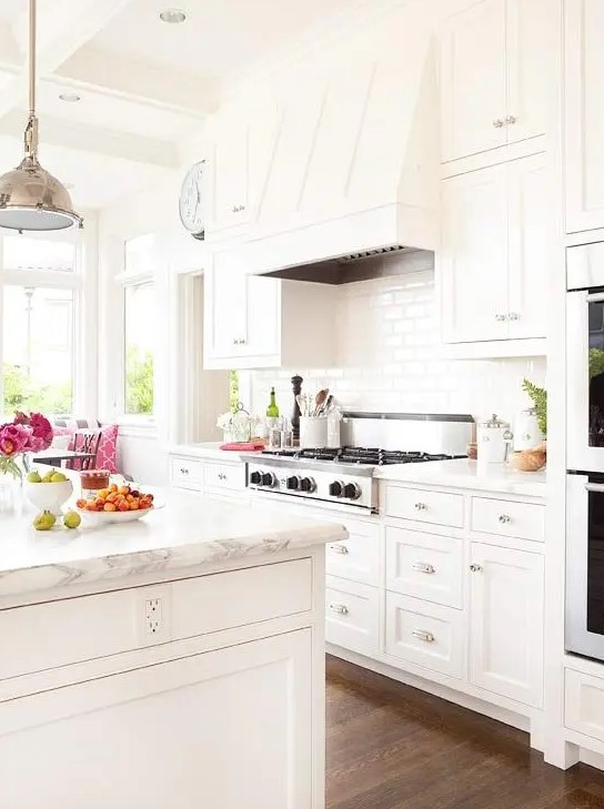 A modern farmhouse kitchen in cream tones with marble countertops looks very chic and inviting