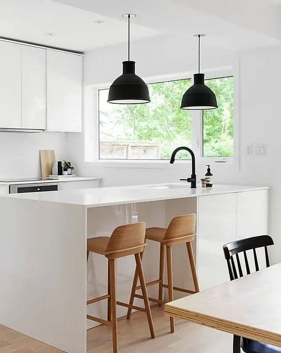 An ultra-modern white room with black lamps and wooden stools looks very laconic and chic