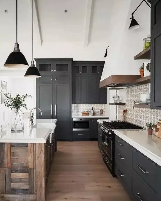 A modern barn kitchen with graphite gray Shaker-style cabinets, white stone countertops, a reclaimed wood island and black lamps