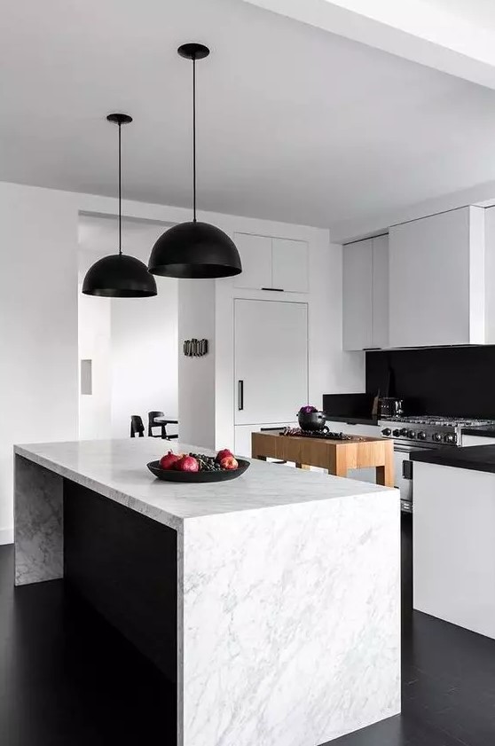 A modern black and white kitchen with sleek cabinets, black countertops and backsplash, and black pendant lamps