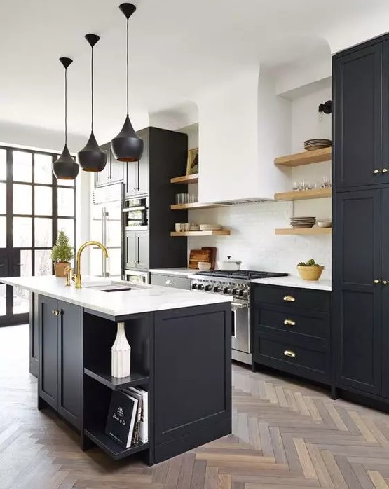 A beautiful modern kitchen with black shaker cabinets and a kitchen island, white stone countertops, a white subway tile backsplash, and black pendant lamps