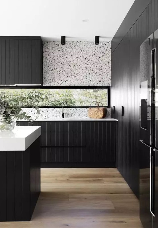 A sleek, modern kitchen with black cabinets, a white terrazzo backsplash, white countertops and black fixtures is a beautiful idea
