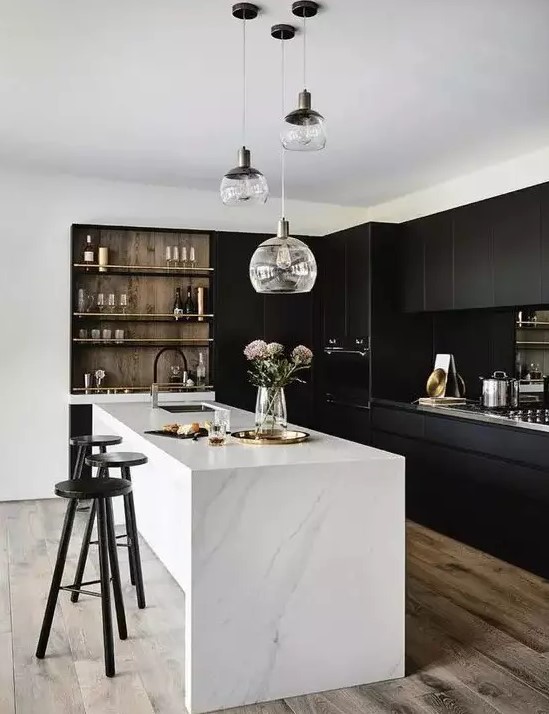 a stylish, contrasting kitchen with sleek black cabinets, a white stone kitchen island, built-in shelving and a range of pendant lamps