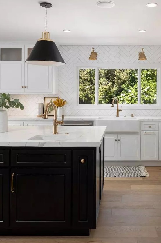 an elegant and sophisticated kitchen with white shaker cabinets, a black kitchen island, white stone countertops and a white chevron tile backsplash