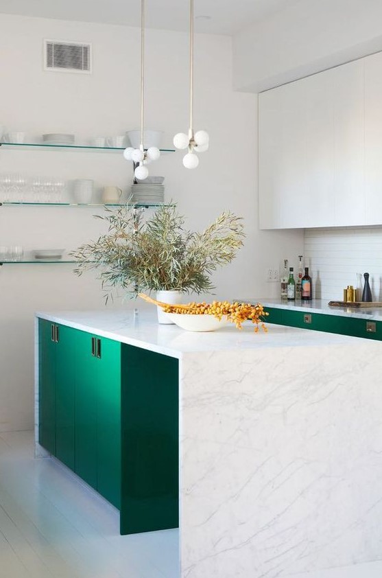 A beautiful emerald green and white kitchen with a white tile backsplash and a beautiful white stone waterfall countertop and chic pendant lamps