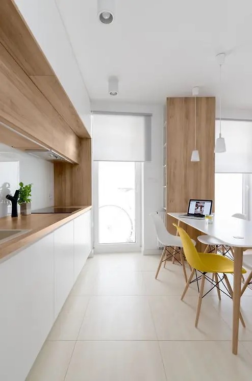 a modern Scandi kitchen with white cabinets and an additional row of stained wooden cabinets and matching worktops