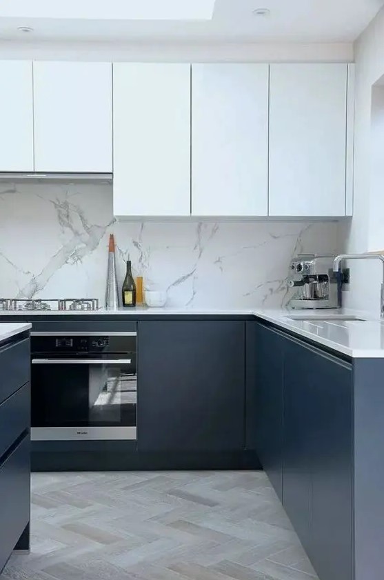 A fabulous modern kitchen with elegant white and navy cabinets, white stone splashback and worktops and a skylight