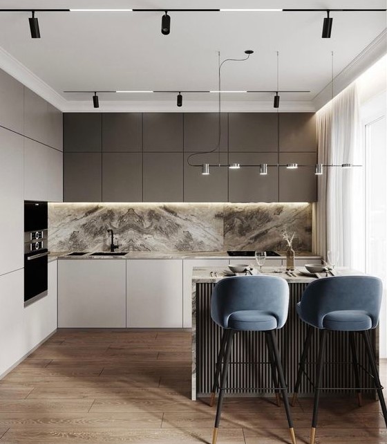 a sophisticated modern kitchen with matte taupe and white cabinets, a white and gray marble backsplash and countertops, and black fixtures