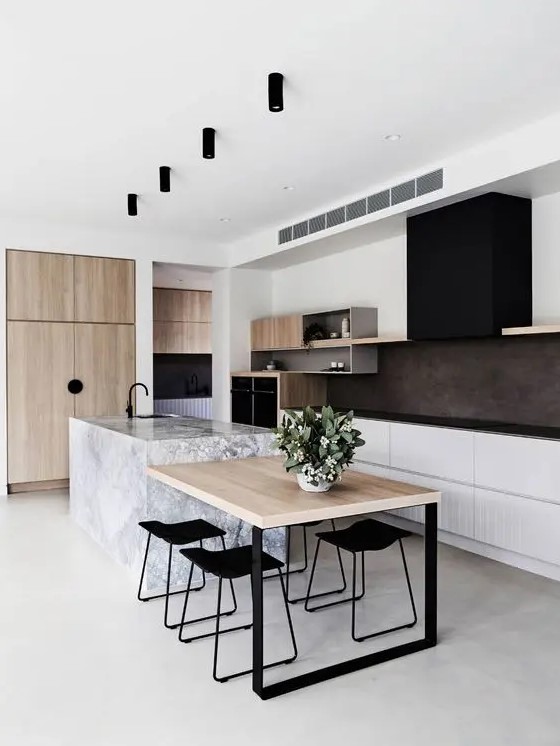 a stylish modern kitchen with white base cabinets, open storage shelving, a black extractor hood, black worktops, light stained wood and a stone kitchen island