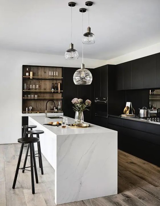 a stylish, contrasting kitchen with sleek black cabinets, a white stone kitchen island, built-in shelving and a range of pendant lamps