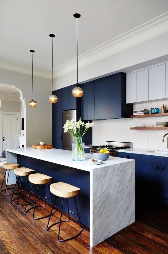 A two-tone modern kitchen with navy and white cabinets, white stone countertops and a tiled splashback and open shelving