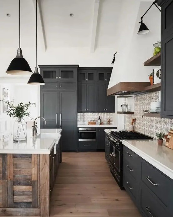A modern barn kitchen with graphite gray Shaker-style cabinets, white stone countertops, a reclaimed wood island and black lamps