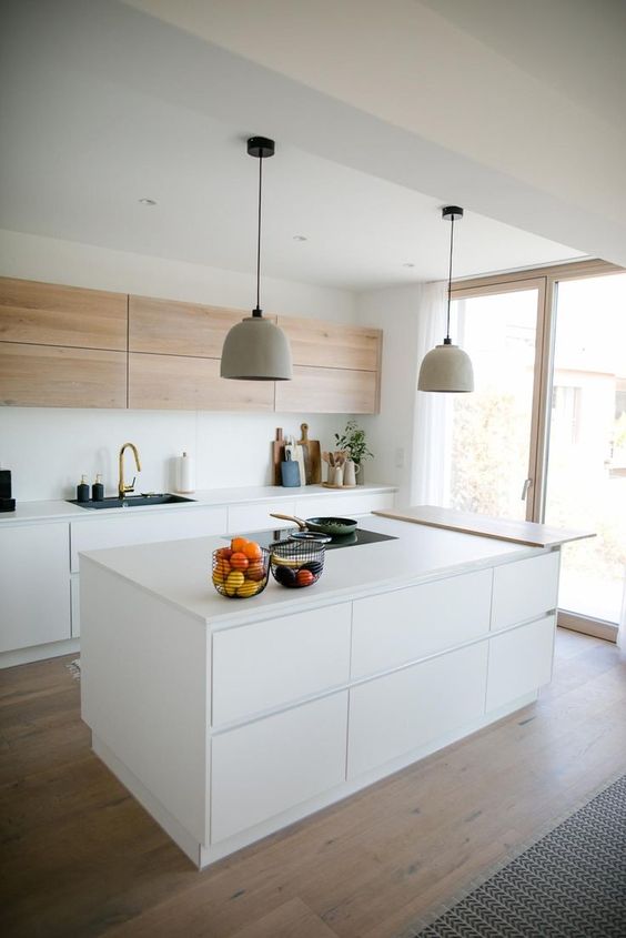 a chic, minimalist kitchen with light stained and white cabinets, a sleek white kitchen island with storage and a dining countertop