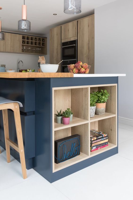a modern kitchen with stained cabinets, a large navy kitchen island with wooden countertops and open shelves for storage