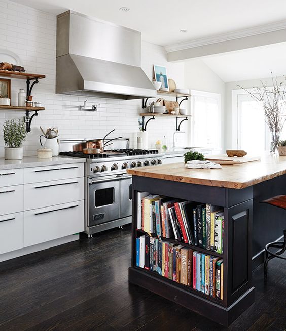 a modern white kitchen with sleek cabinets, white tile and stainless steel appliances, and a black kitchen island with open shelving