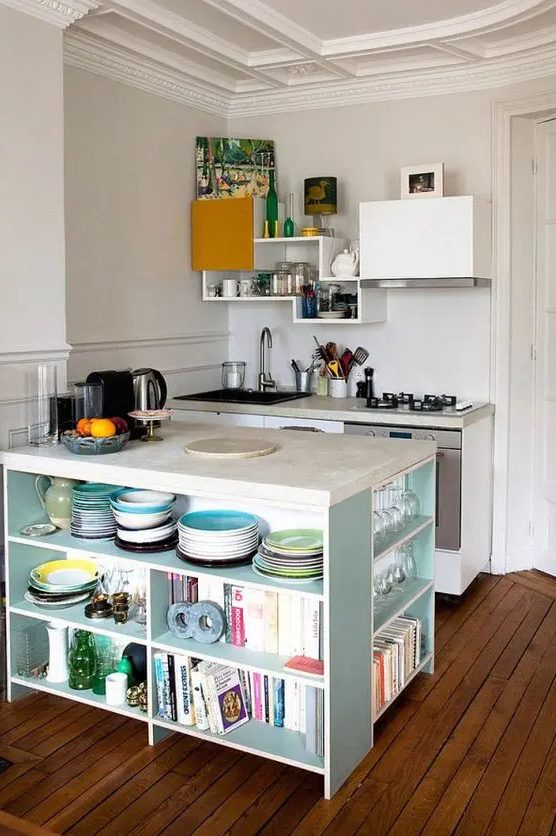 a tiny kitchen with white cabinets, neutral countertops, statement upper cabinets, and a light blue kitchen island with open shelves to store all the essentials