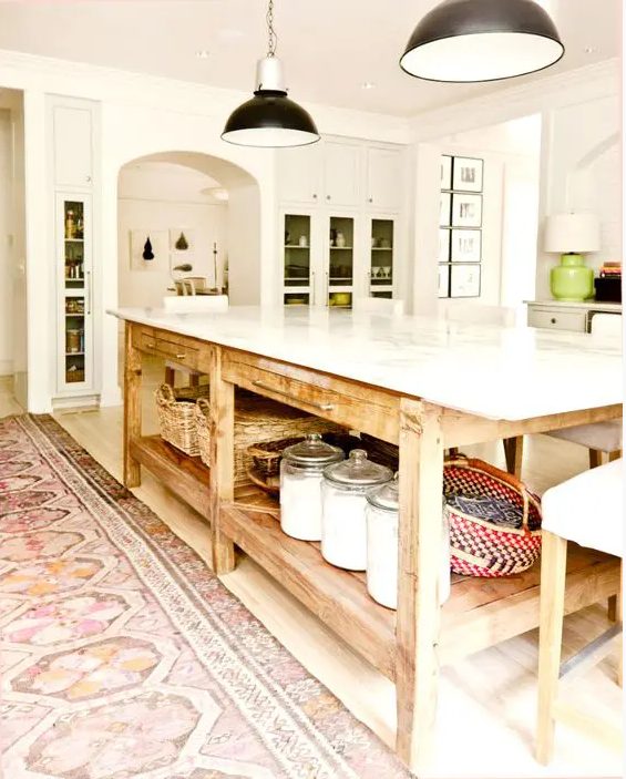 a white kitchen island with glass cabinets, green accents and green backing, an oversized kitchen island that is a table with open storage and tiny drawers