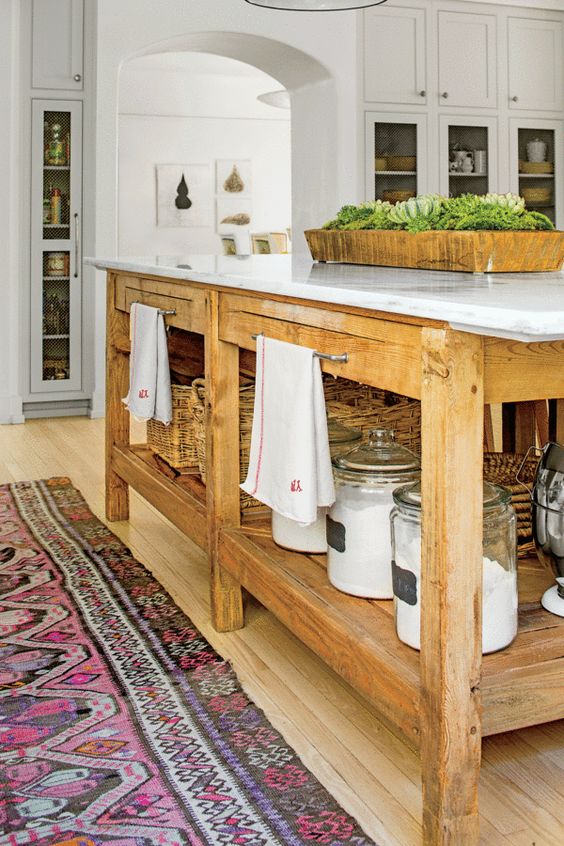 An oversized stained kitchen island with open shelves for storage and holders for towels is a very functional and cool solution