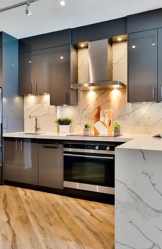 A chic taupe kitchen with glossy cabinets, a white marble tile backsplash and countertops, and built-in appliances is a bold idea