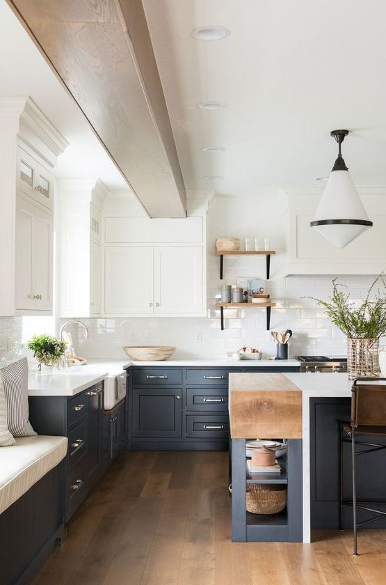 a sophisticated two-tone kitchen with navy and white shaker-style cabinets, white countertops and a subway tile backsplash, and a retro pendant lamp