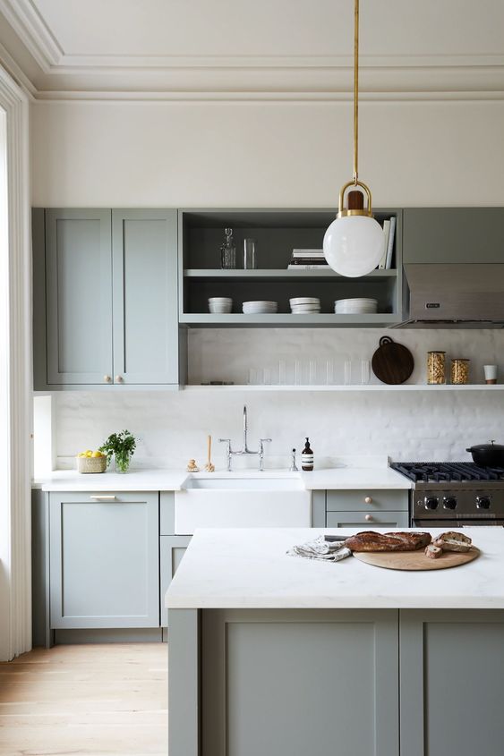 A sleek dove gray kitchen with shaker cabinets, open shelving, a white tile backsplash, and white quartz countertops