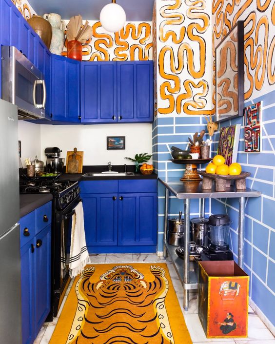 A maximalist bold blue kitchen with light blue tiles and crazy tiger-inspired prints is a bold and fantastic idea