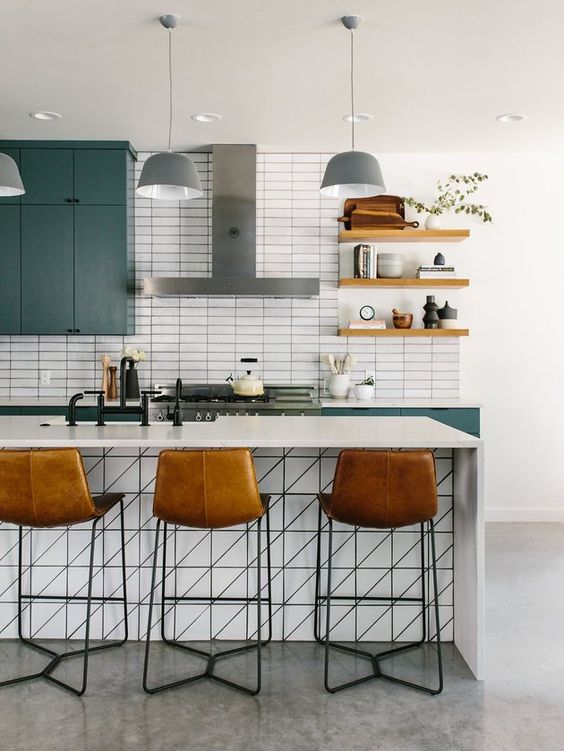 A fantastic mid-century modern kitchen with green cabinets, a white island, open shelving and leather stools