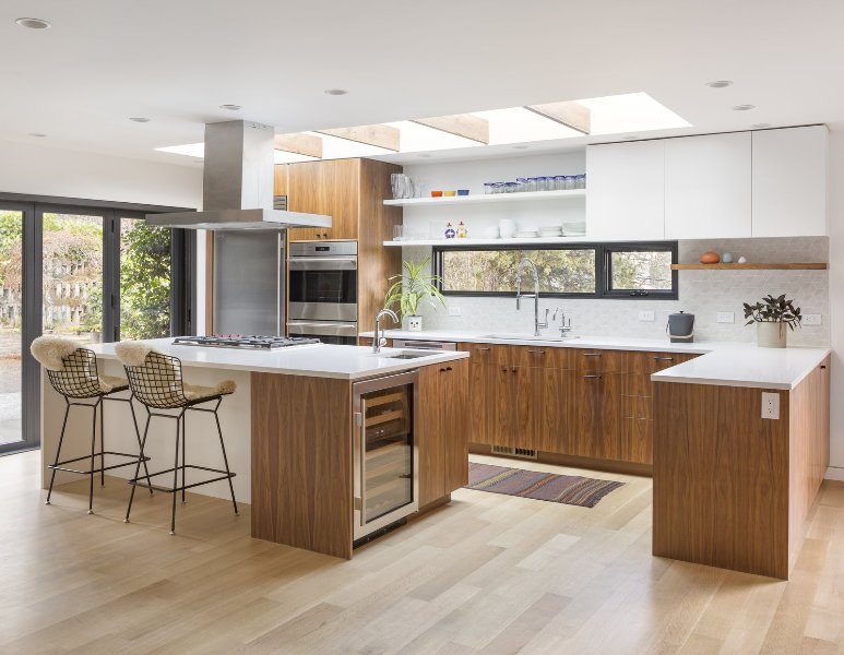 A fantastic mid-century modern stained kitchen with white countertops, geotile backsplash, window and skylights