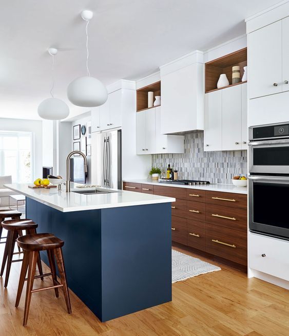 A fabulous mid-century modern kitchen with two-tone cabinets, white countertops, a mosaic tile backsplash and a navy blue kitchen island