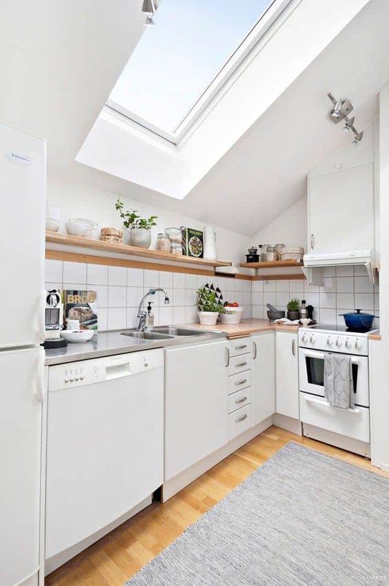 a small Scandinavian attic kitchen with butcher block countertops, a skylight, open shelving and square tiles