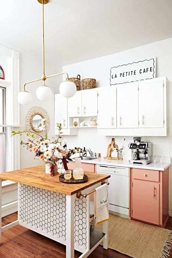 a modern kitchen in coral pink and white with gold handles, a chic small kitchen island with hexagonal tiles that catches the eye