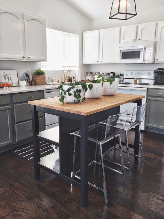 a two-tone white and gray kitchen with white countertops and a small black kitchen island with storage and dining area for contrast