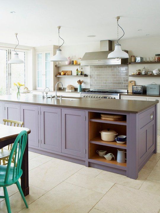 a neutral kitchen with a lavender kitchen island, taupe countertops and retro pendant lamps, as well as a gray tile backsplash