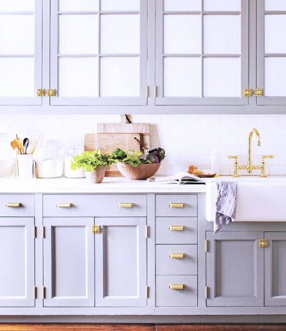 A romantic purple kitchen with a white subway tile backsplash and white countertop and gold accents