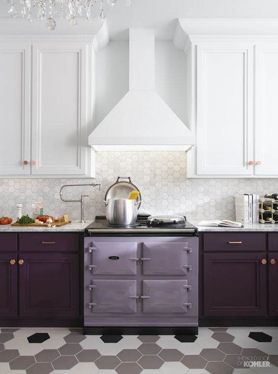 a stylish kitchen with white upper cabinets and plum-colored lower cabinets, a purple stove and a splashback made of white hexagonal tiles