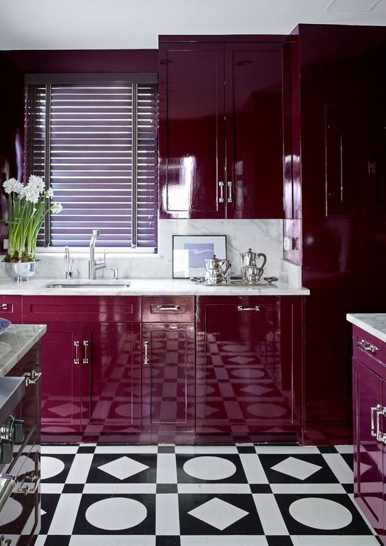 a magnificent plum kitchen with a white stone worktop and backsplash, a patterned tile floor and some flowers